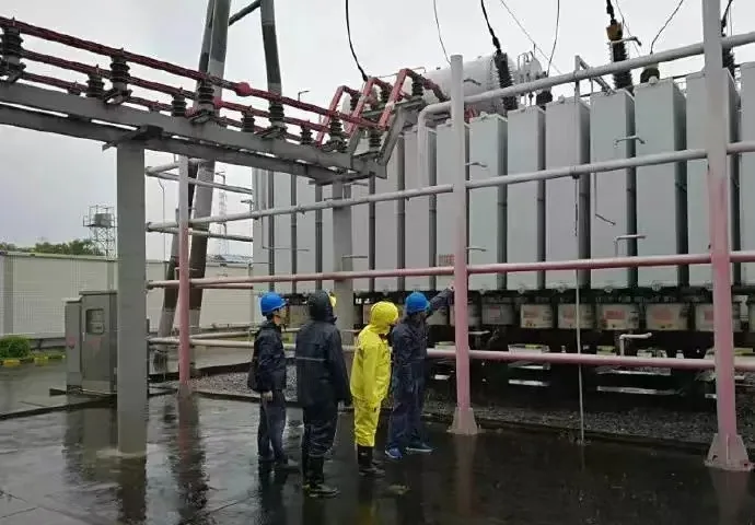Substation transformer environmental inspection during rain showing humidity and drainage conditions