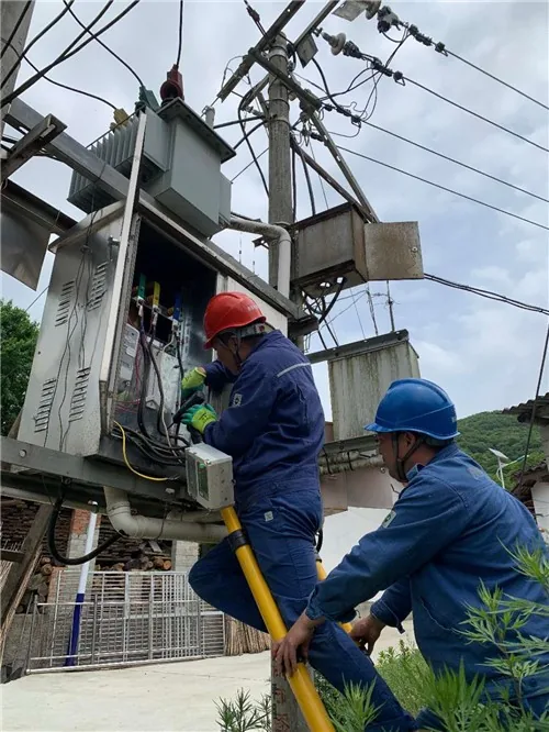 Electrical technicians inspecting transformer capacity and field wiring before load expansion